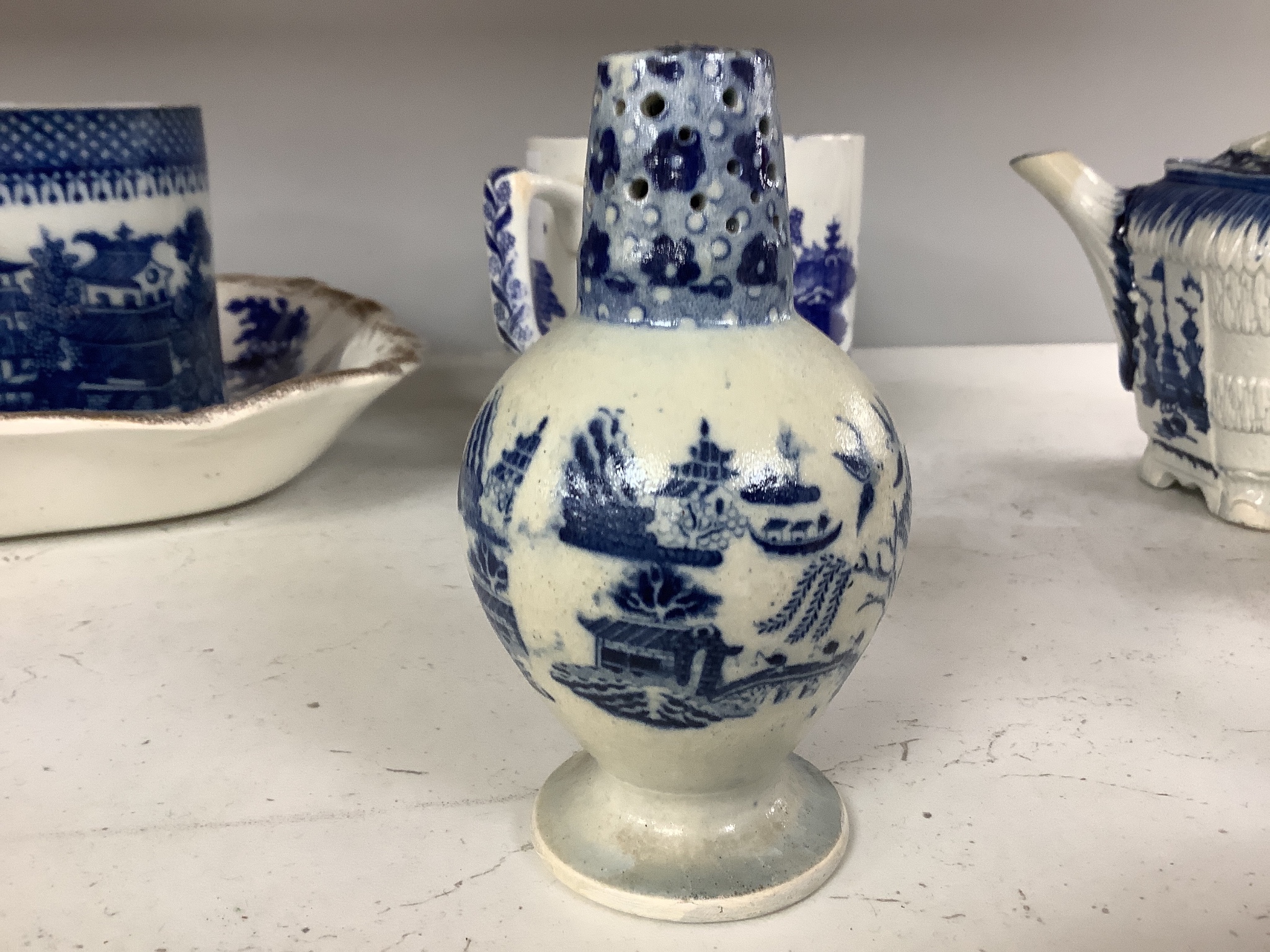 A collection of English blue and white pottery, various dates, comprising a moulded hexagonal teapot and cover, with widow finial, ovoid teapot and cover, lozenge section sugar bowl and cover, with swan finial, circular
